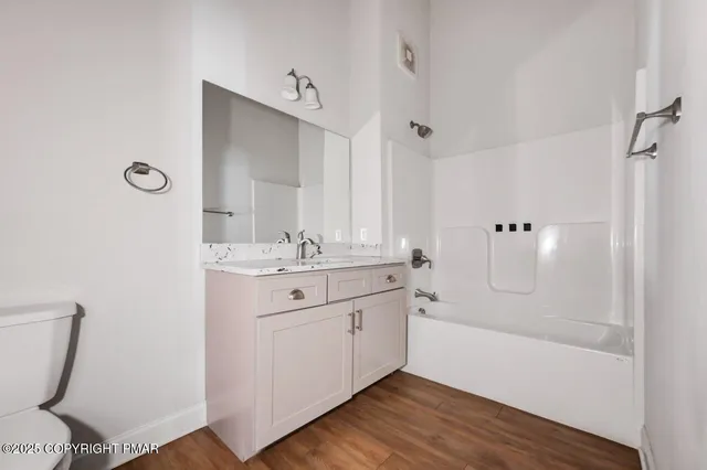 a bathroom with a granite countertop sink toilet and shower