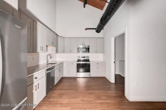 a kitchen with stainless steel appliances granite countertop a stove top oven and sink