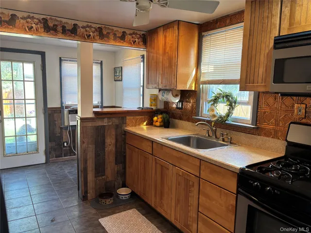a kitchen with a sink and a stove next to a window