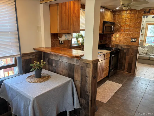 a kitchen with stainless steel appliances kitchen island granite countertop a sink dishwasher stove and refrigerator