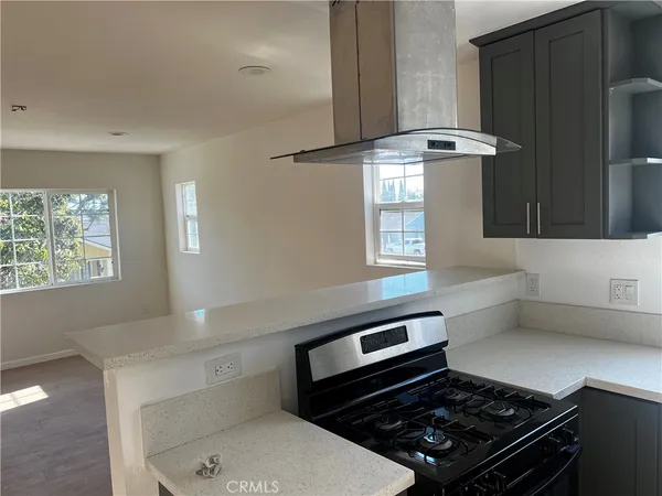 a kitchen with a stove and white cabinets