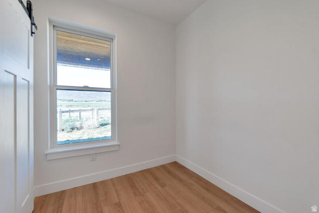 1820 West Farmhouse Flats Road Peoa, UT 84061 - Photo 73 of 79 Bright interior space featuring wood-finish flooring, white walls, and a large window with a white frame