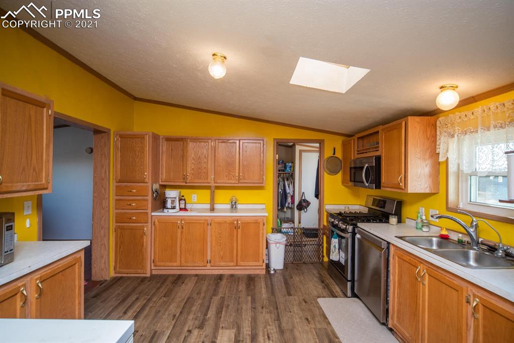 12495 Dan View Yoder, CO 80864 - Photo 8 of 40 a kitchen with stainless steel appliances wooden floors stove top oven and sink