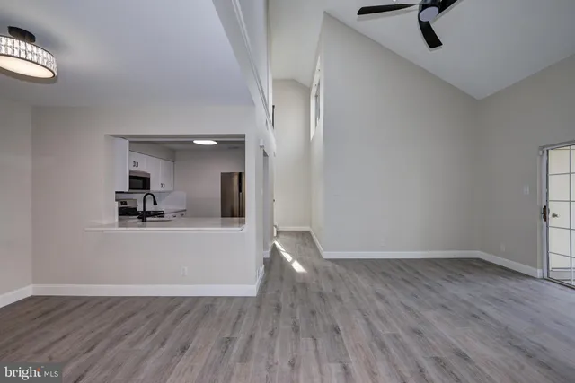 a view of a room with wooden floor and a ceiling fan