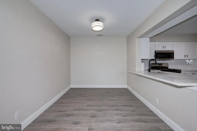 a view of kitchen with wooden floor and electronic appliances