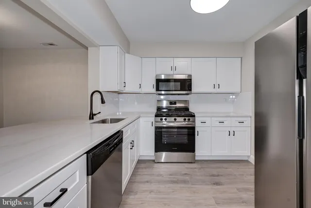 a kitchen with stainless steel appliances a sink stove and refrigerator