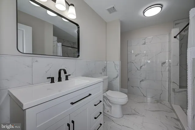 a bathroom with a sink toilet a mirror and shower