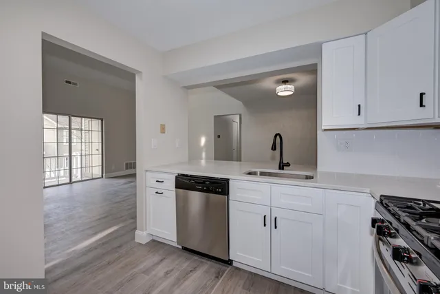 a kitchen with white cabinets and appliances