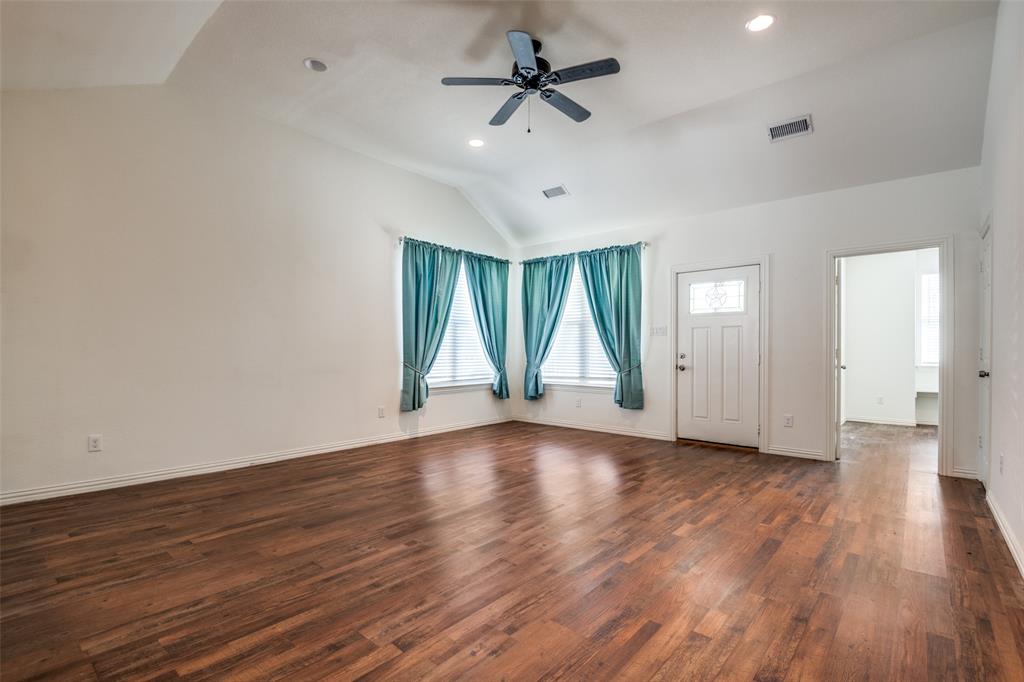 2412 Colquitt Road Terrell, TX 75160 - Photo 6 of 24 a view of an empty room with wooden floor and a window