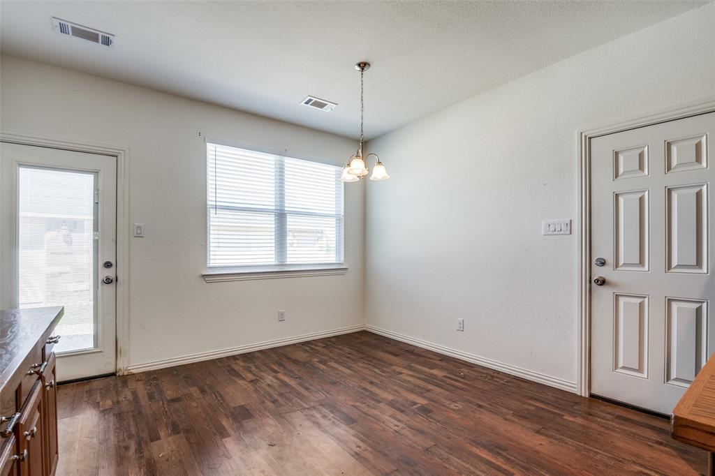 2412 Colquitt Road Terrell, TX 75160 - Photo 10 of 24 an empty room with wooden floor and windows