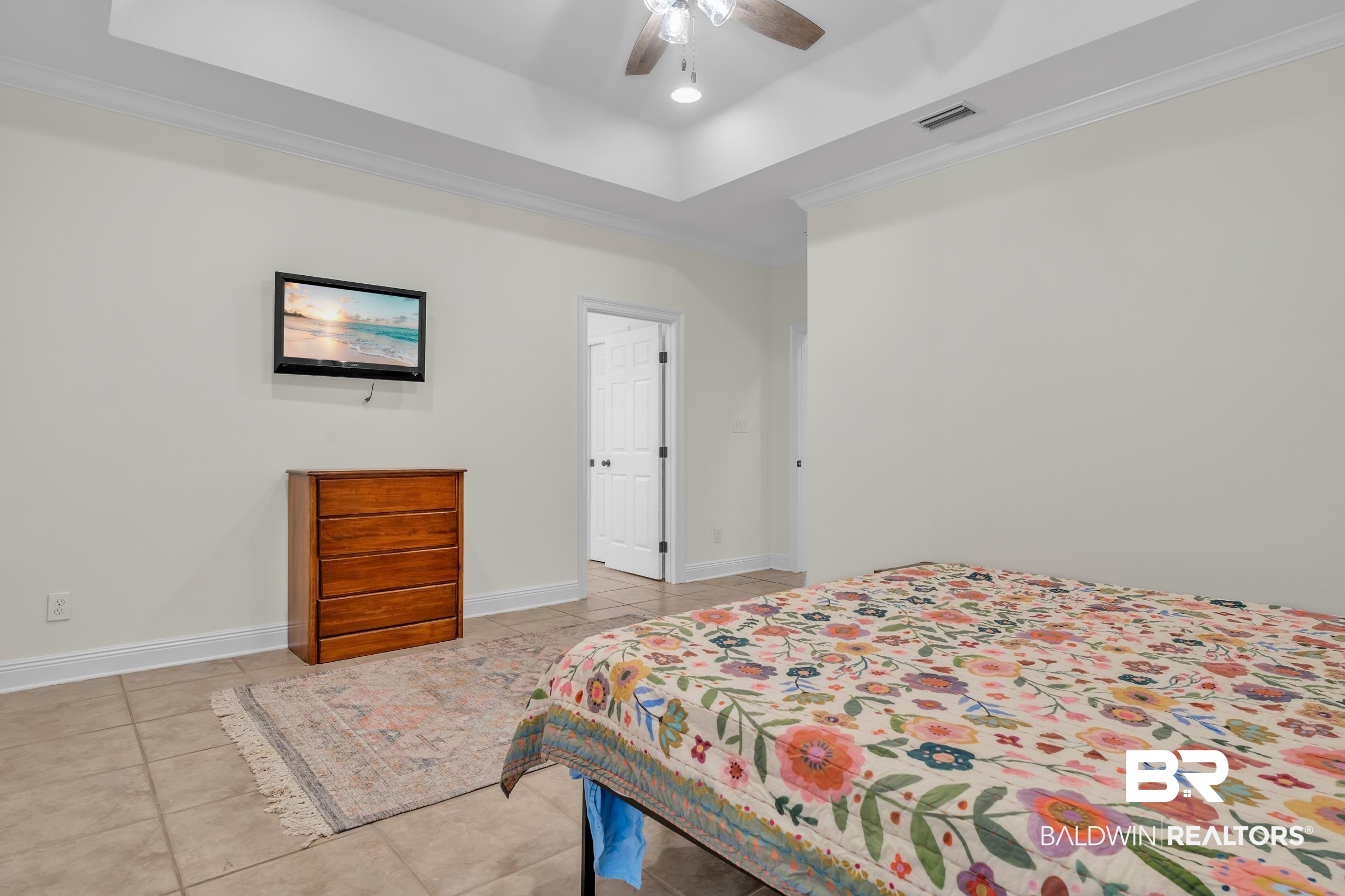 4606 Osprey Drive Orange Beach, AL 36561 - Photo 28 of 44 Bedroom featuring light tile patterned floors, a tray ceiling, crown molding, and ceiling fan