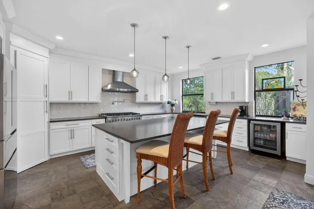 a kitchen with stainless steel appliances granite countertop a sink a stove and a refrigerator