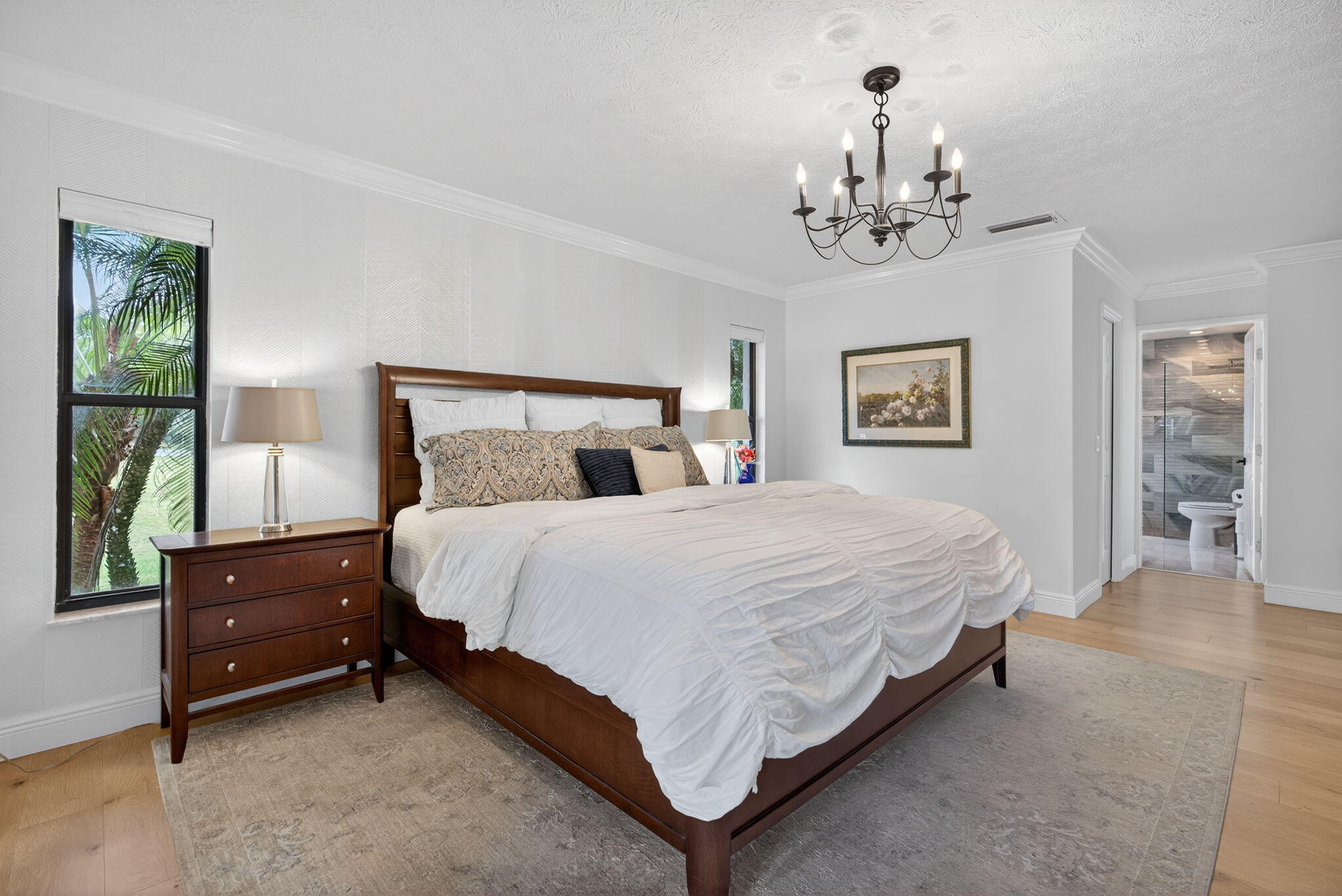 1488 Southeast Colony Way Jupiter, FL 33478 - Photo 20 of 51 a bedroom with a bed chandelier and windows