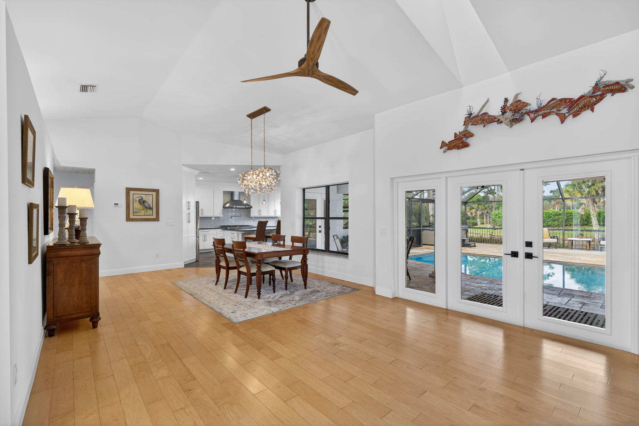 1488 Southeast Colony Way Jupiter, FL 33478 - Photo 9 of 51 a dining room with furniture a chandelier and wooden floor