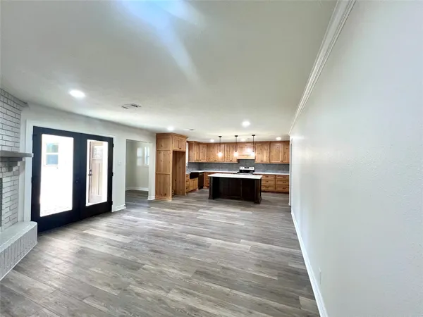 a view of an empty room with window and wooden floor