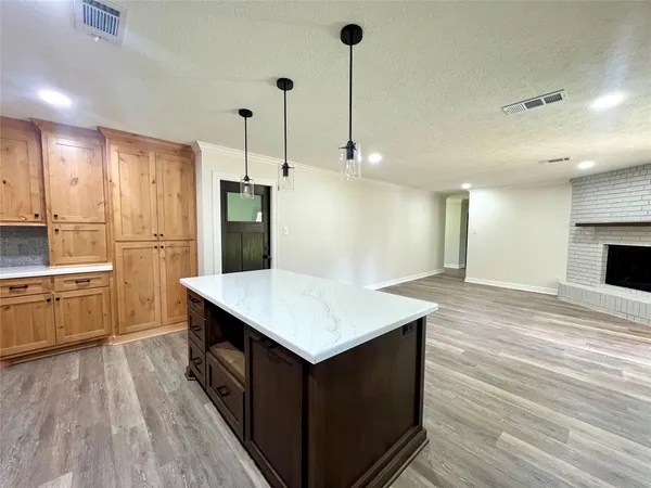 a kitchen with kitchen island a sink dishwasher a stove and a refrigerator with wooden floor