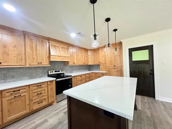 a kitchen with a wooden floor sink and cabinets