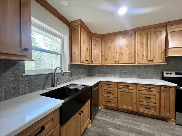 a kitchen with stainless steel appliances granite countertop a sink a stove and a microwave