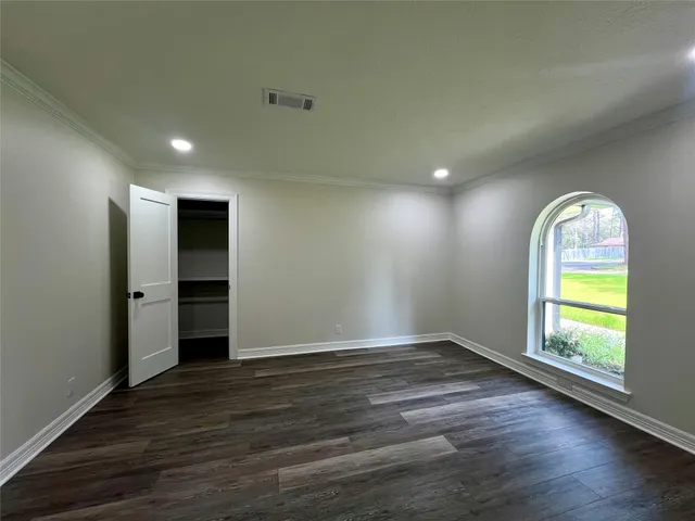 an empty room with wooden floor and window
