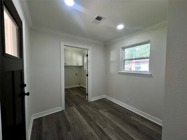 an empty room with wooden floor and windows