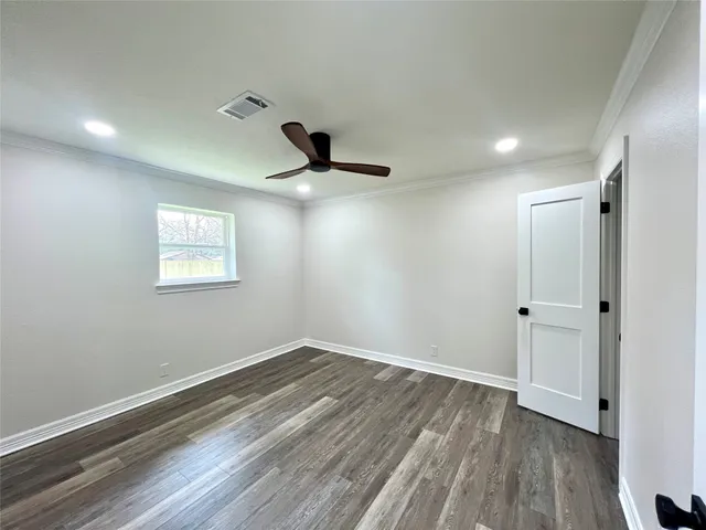 a view of a room with a wooden floor and fan