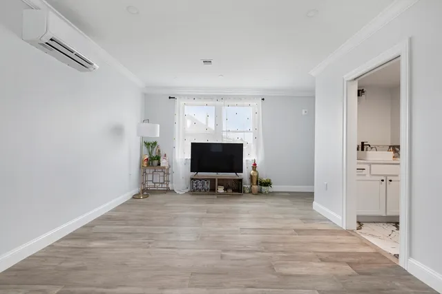 a view of a livingroom with wooden floor and a flat screen tv