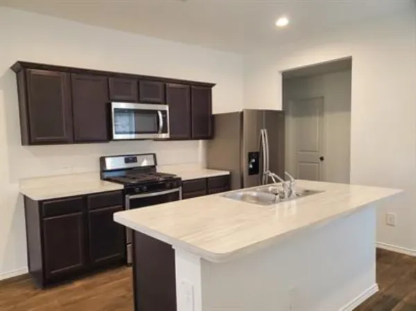 a kitchen with a sink a microwave a stove and refrigerator