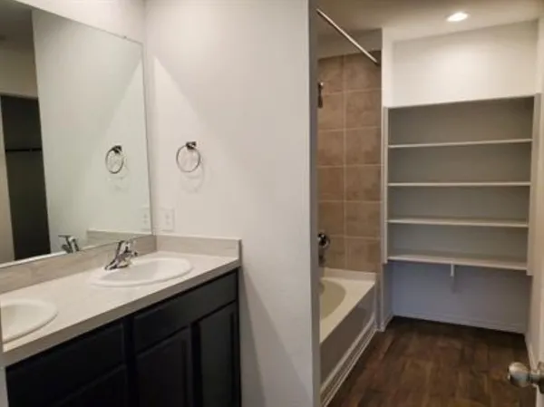 a bathroom with a sink a tub and a mirror