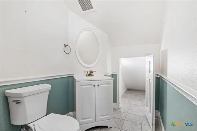 a bathroom with a toilet a sink and a mirror