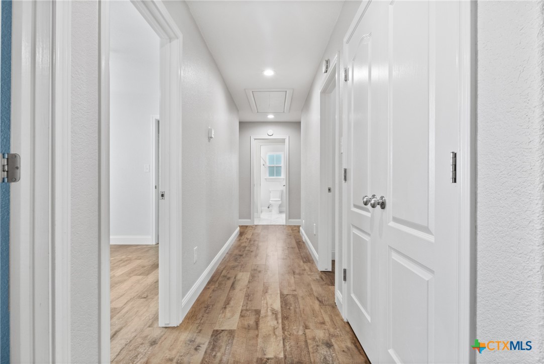 275 Woodruff Road Waco, TX 76705 - Photo 33 of 45 a view of a hallway with wooden floor and a bathroom