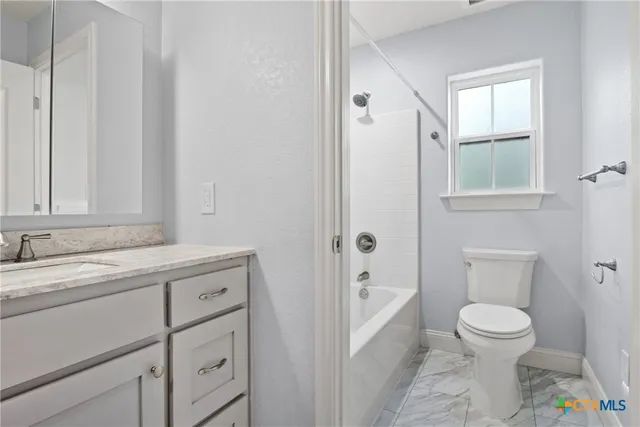 a bathroom with a granite countertop sink a toilet and a bathtub