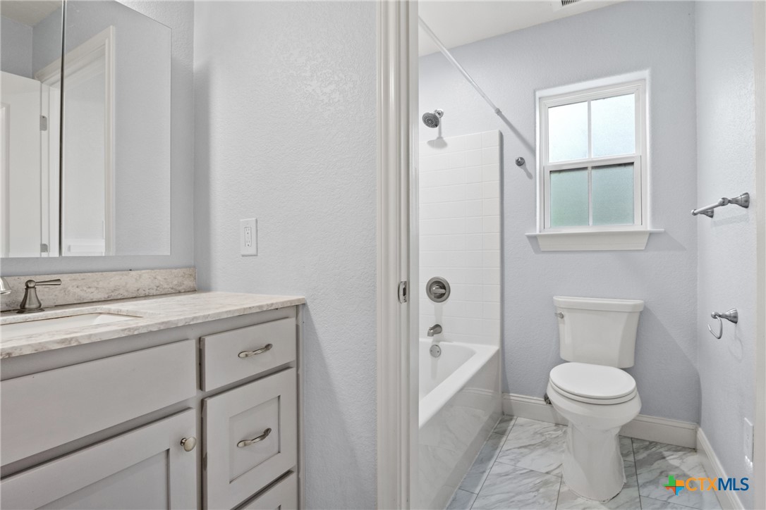 275 Woodruff Road Waco, TX 76705 - Photo 38 of 45 a bathroom with a granite countertop sink a toilet and a bathtub
