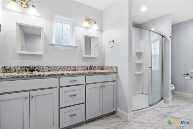a bathroom with a granite countertop sink a mirror and a shower