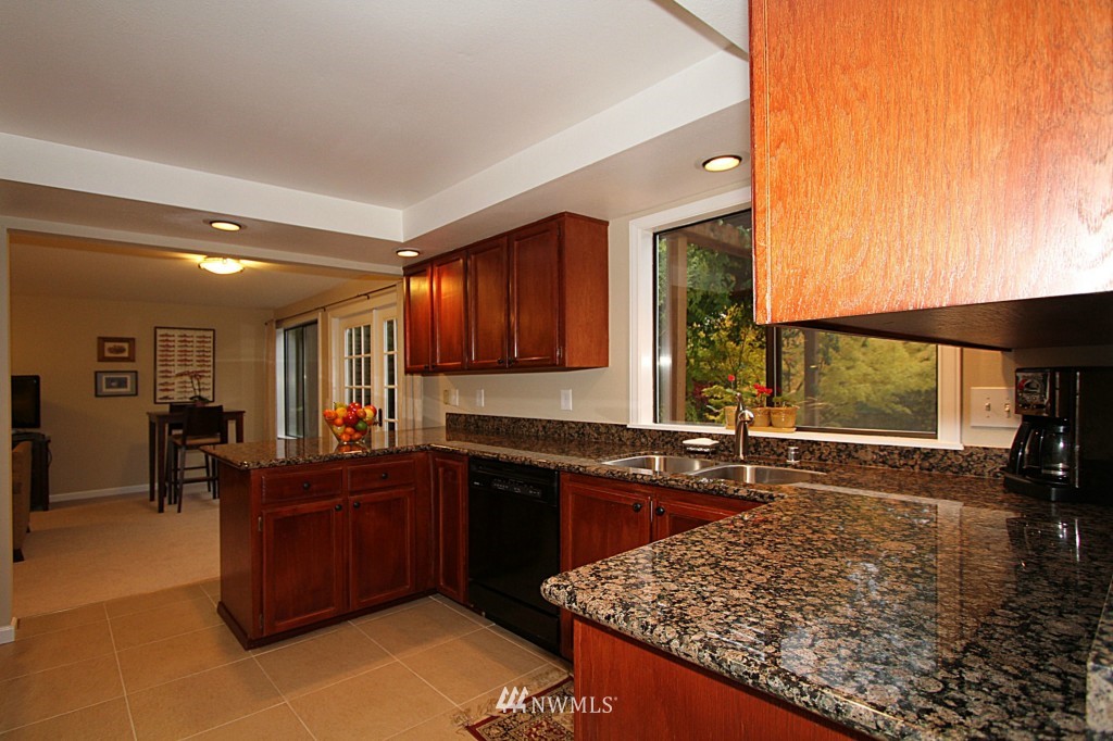 24200 16th Place Southeast Bothell, WA 98021 - Photo 4 of 14 a kitchen with granite countertop a sink dishwasher stove and cabinets