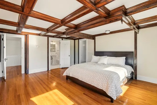 a spacious bedroom with a bed and wooden floor