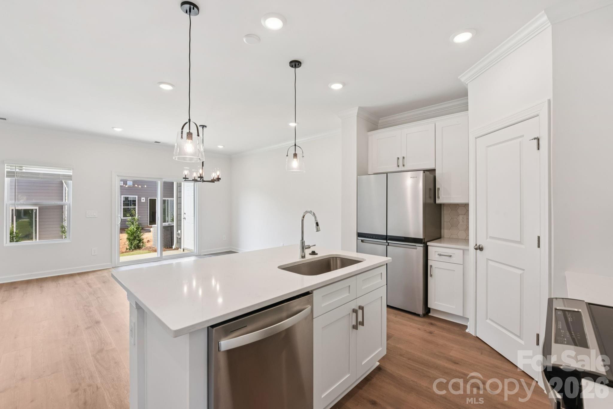 445 Markridge Loop Fort Mill, SC 29708 - Photo 4 of 13 a kitchen with stainless steel appliances granite countertop a sink a refrigerator a stove a kitchen island with wooden floor and cabinets