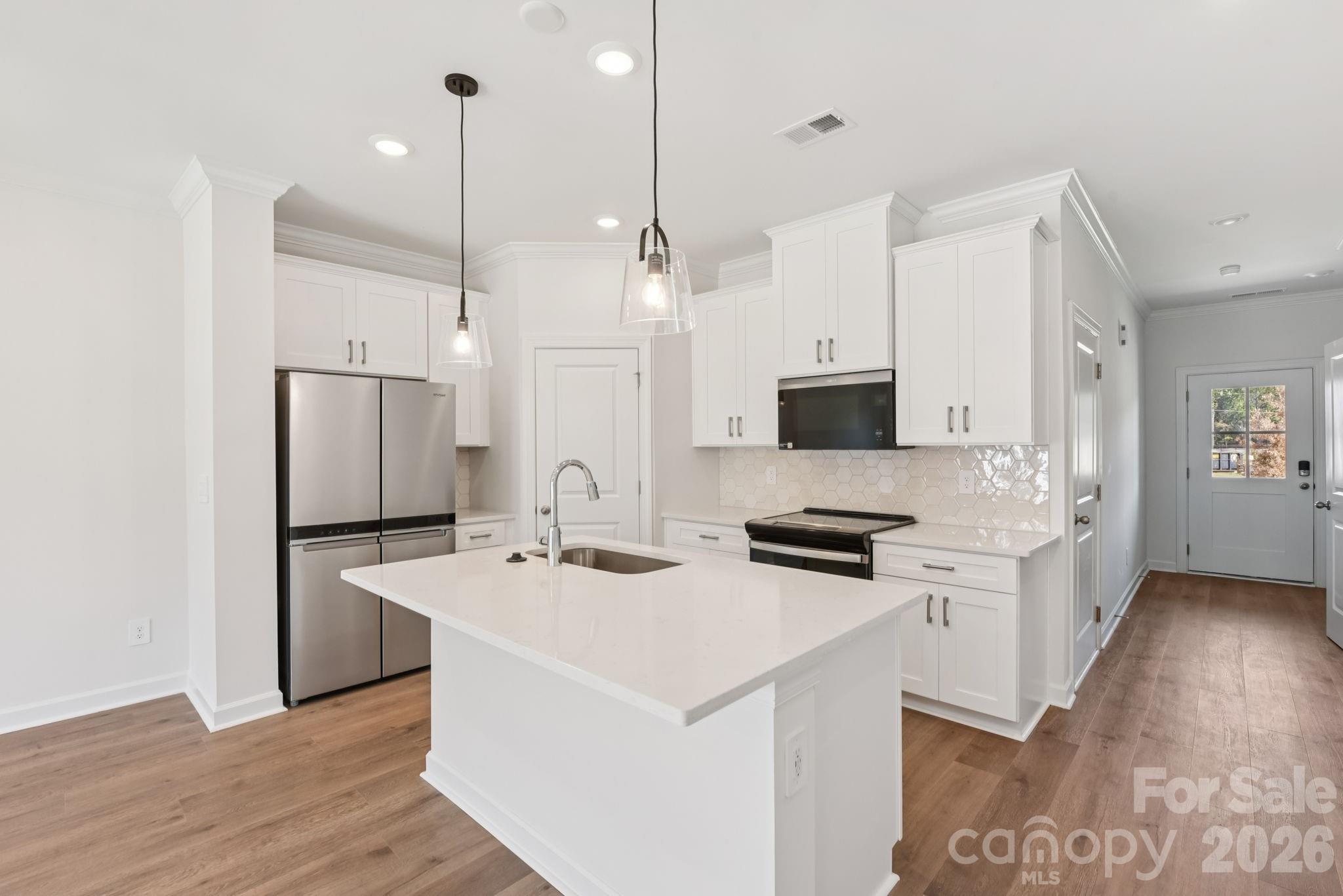 445 Markridge Loop Fort Mill, SC 29708 - Photo 5 of 13 a kitchen with stainless steel appliances a stove top oven a sink a refrigerator a center island and cabinets