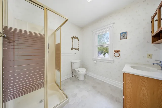 a bathroom with a granite countertop sink a toilet and shower
