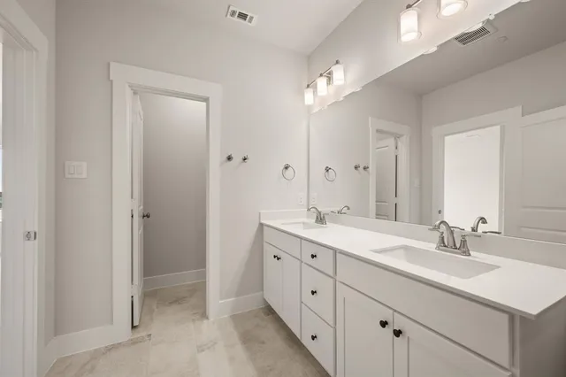 a view of a hallway with wooden floor and a bathroom