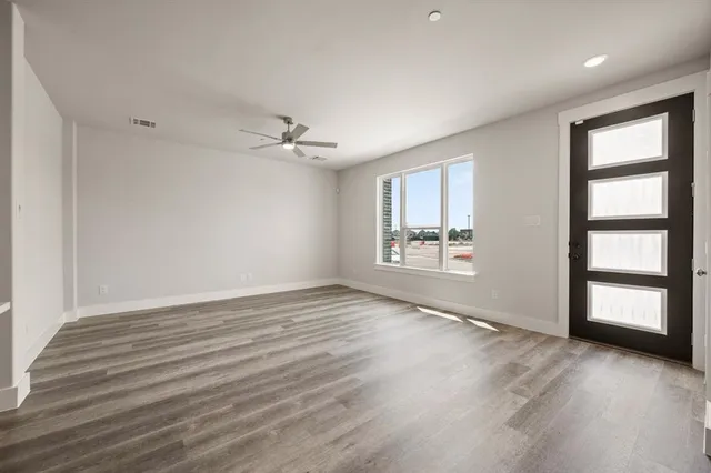 an empty room with window and wooden floor