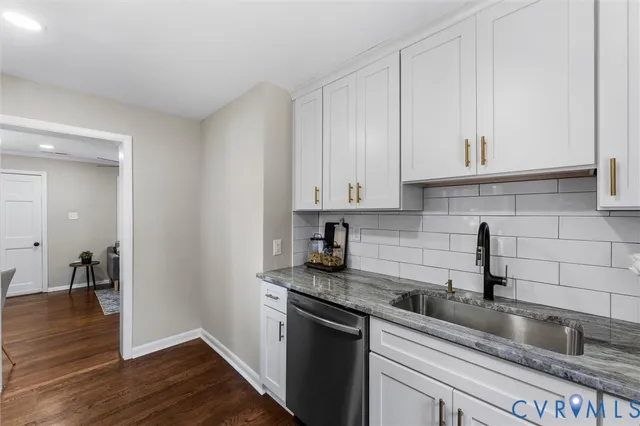 a kitchen with granite countertop a sink stainless steel appliances and cabinets