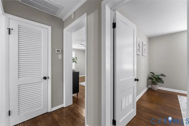 a view of a hallway with wooden floor and closet area
