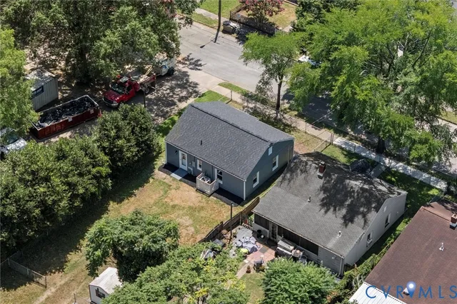 an aerial view of a house with a yard and large trees
