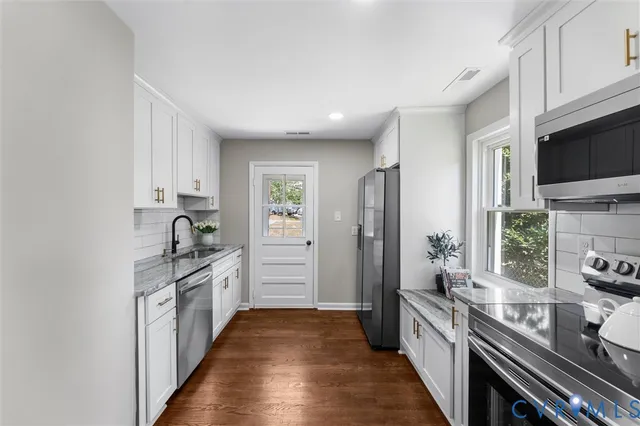 a kitchen with stainless steel appliances granite countertop a stove and a refrigerator