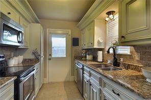 1315 North Floyd Road Richardson, TX 75080 - Photo 13 of 26 a kitchen with stainless steel appliances granite countertop a sink stove and cabinets