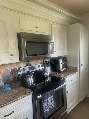 a kitchen with stainless steel appliances wooden cabinets and a stove top oven