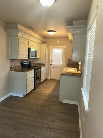 a kitchen with a sink and wooden floor