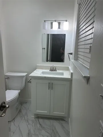 a bathroom with a sink toilet and mirror