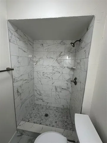 a bathroom with a toilet and a shower
