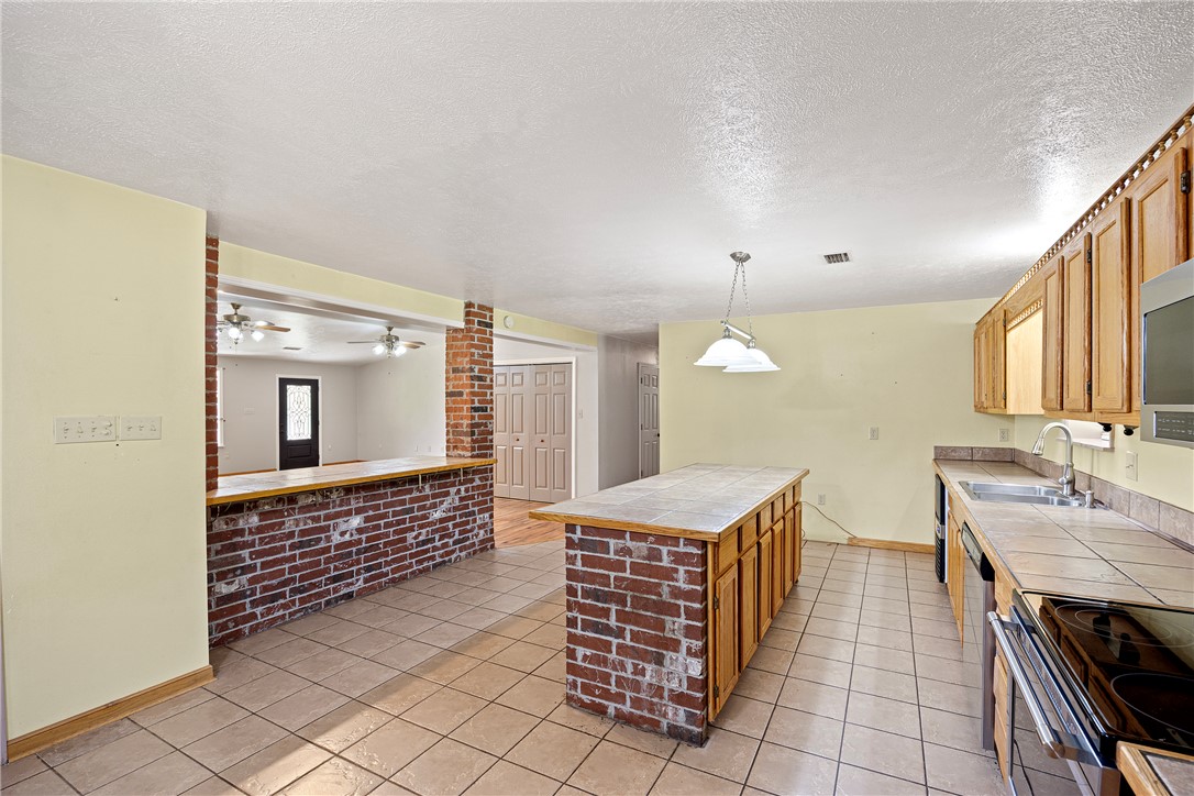 655 Charton Road Morrilton, AR 72110 - Photo 11 of 49 Spacious kitchen featuring tile flooring, wooden cabinetry, and a tile countertop